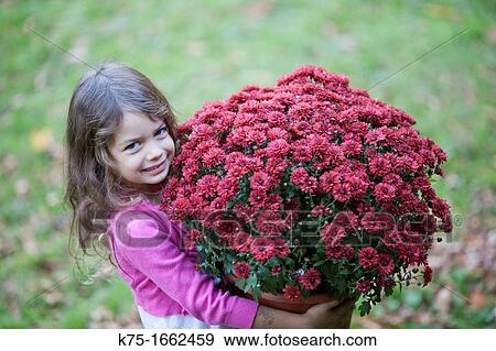 Stock Photo - Little girl carrying large pot of flowers. Fotosearch