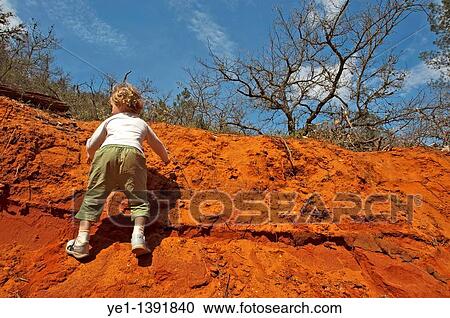 Little girl climbing up a red, sandy cliff, Rustrel, Provence, France View Large Photo Image Stock Image - Little girl climbing up a red, sandy cliff, Rustrel, Provence, France. Fotosearch