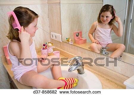 Little girl combing her hair in the bathroom View Large Photo Image Stock Image - Little girl combing her hair in the bathroom. Fotosearch