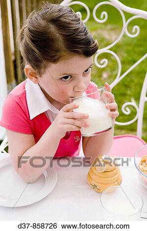 Stock Photograph - Little girl drinking a glass of milk. Fotosearch