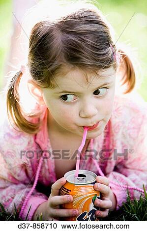 Stock Image - Little girl drinking soda with a straw. Fotosearch