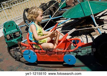 Little girl driving a car on a merry go round ride in Remedios Amusement Park, Cuba. View Large Photo Image Stock Image - Little girl driving a car on a merry go round ride in Remedios Amusement Park, Cuba.. Fotosearch