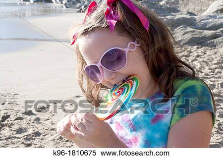 Stock Photography - little girl eating a big sucker. Fotosearch