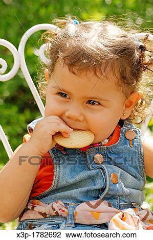 Little girl eating a cookie View Large Photo Image Stock Image - Little girl eating a cookie. Fotosearch