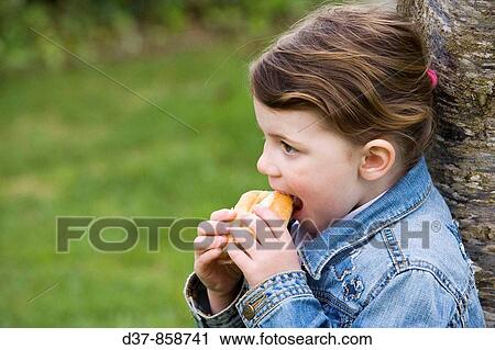 Little girl eating a sandwich in the park View Large Photo Image Stock Image - Little girl eating a sandwich in the park. Fotosearch