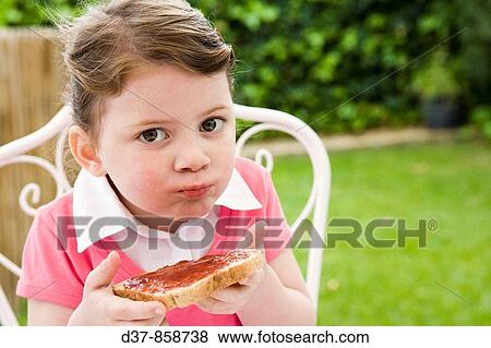 Little girl eating bread with jam View Large Photo Image Stock Photo - Little girl eating bread with jam. Fotosearch
