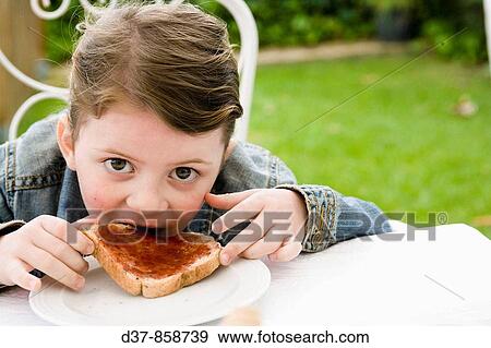 Little girl eating bread with jam View Large Photo Image Stock Photo - Little girl eating bread with jam. Fotosearch