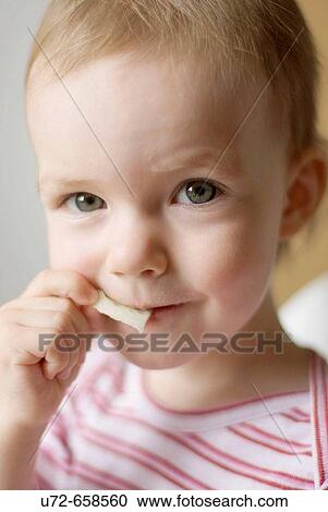 Stock Image - Little Girl Eating Snack. Fotosearch