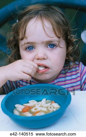 Stock Photography - Little girl eating soup. Fotosearch