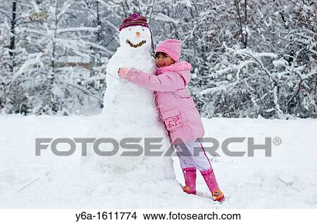 Little girl embracing snowman, smiling, portrait View Large Photo Image Picture - Little girl embracing snowman, smiling, portrait. Fotosearch