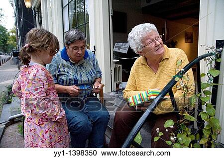 Little girl giving present to elder ladies. View Large Photo Image Stock Image - Little girl giving present to elder ladies.. Fotosearch