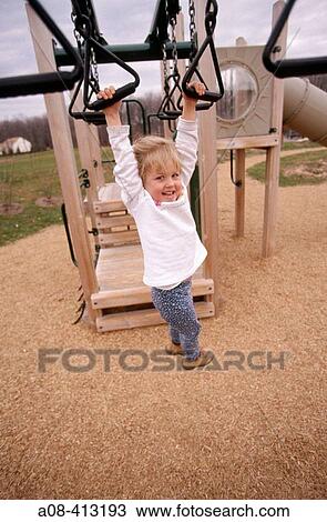 Little girl hangs from playground climber. USA. View Large Photo Image Stock Image - Little girl hangs from playground climber. USA.. Fotosearch