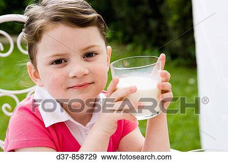 Little girl holding a glass of milk View Large Photo Image Stock Photo - Little girl holding a glass of milk. Fotosearch