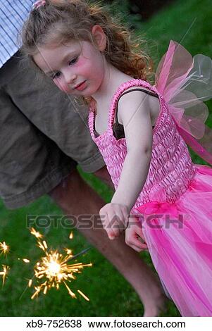 Little girl holding a sparkler View Large Photo Image Stock Photo - Little girl holding a sparkler. Fotosearch