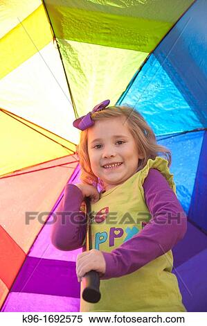 Little girl holding colorful umbrella View Large Photo Image Stock Photography - Little girl holding colorful umbrella. Fotosearch