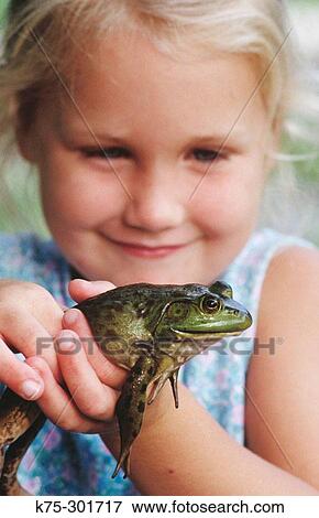 Stock Photo - Little girl holding frog. Fotosearch