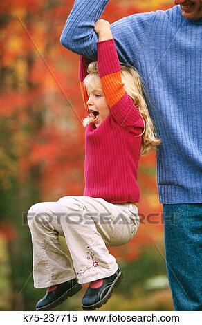 Stock Photography - Little girl holding onto strong daddy. Fotosearch