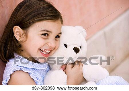 Little girl hugging a teddy bear View Large Photo Image Stock Photo - Little girl hugging a teddy bear. Fotosearch