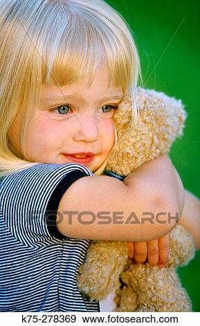 Little girl hugging her teddy bear View Large Photo Image Stock Photo - Little girl hugging her teddy bear. Fotosearch