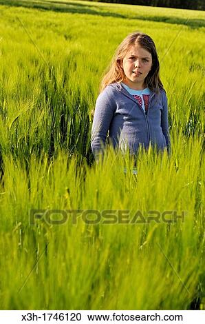 Stock Image - little girl in a barley field, commune of Senantes, Eure-et-Loire department, Centre region, France, Europe. Fotosearch