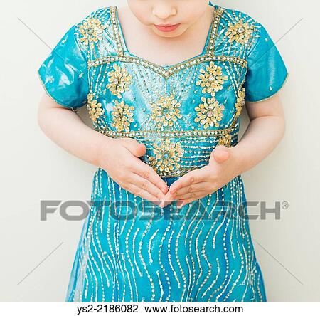 Little girl in blue dress lokking down at her hands, serious and concentrated. View Large Photo Image Stock Image - Little girl in blue dress lokking down at her hands, serious and concentrated.. Fotosearch