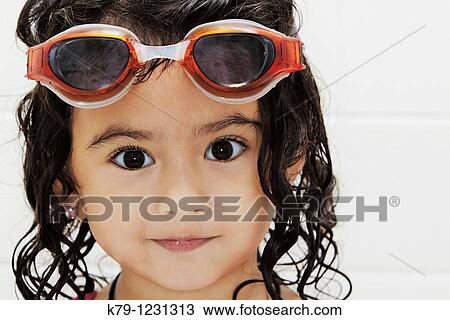 Stock Image - Little girl in swim suit and swim goggles.. Fotosearch