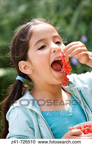 Little girl is eating red berries View Large Photo Image Stock Image - Little girl is eating red berries. Fotosearch