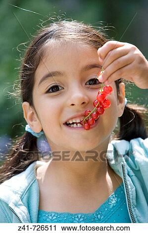 Little girl is eating red berries View Large Photo Image Stock Image - Little girl is eating red berries. Fotosearch