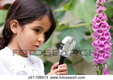 Little girl is looking through a magnifying glass View Large Photo Image Stock Image - Little girl is looking through a magnifying glass. Fotosearch