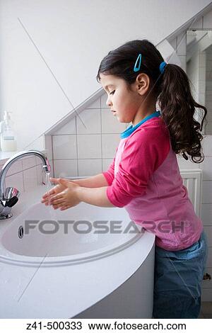 Stock Image - Little girl is washing her hands. Fotosearch