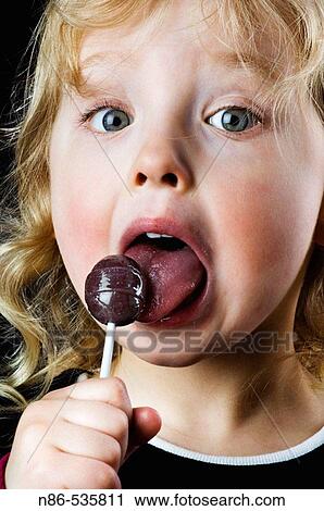 Little girl licking a sucker View Large Photo Image Stock Image - Little girl licking a sucker. Fotosearch