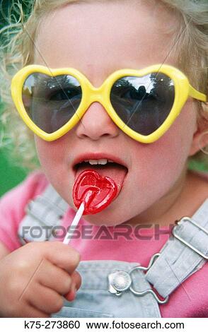 Little girl licking her lollipop View Large Photo Image Stock Image - Little girl licking her lollipop. Fotosearch