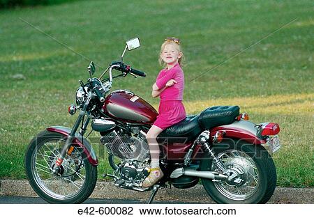Stock Image - Little girl on motorbike. Fotosearch