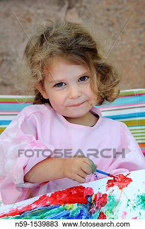 Stock Image - Little girl painting. Fotosearch