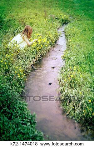Stock Photo - Little Girl Picking Flowers. Fotosearch