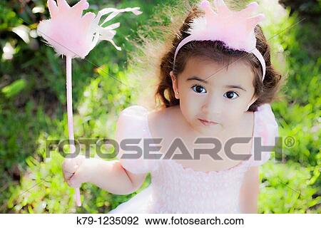 Stock Image - Little girl playing dress up as a princess.. Fotosearch