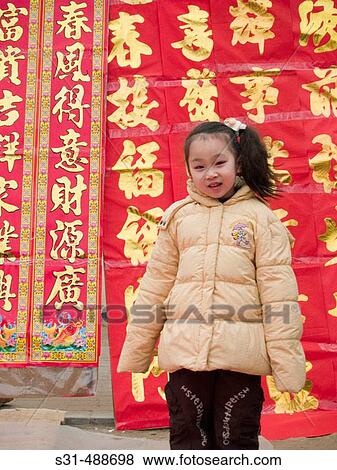 Stock Photo - Little girl playing in front of Chinese scrolls. Fotosearch