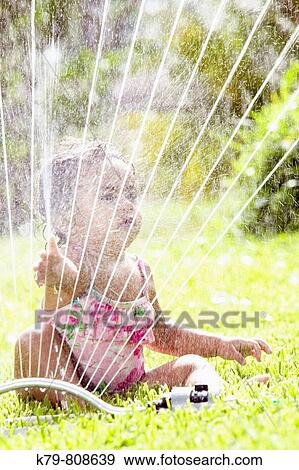 Little girl playing in sprinkler. View Large Photo Image Stock Photo - Little girl playing in sprinkler.. Fotosearch