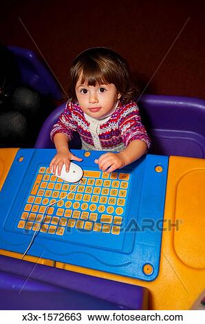 Little girl playing with a children computer View Large Photo Image Stock Image - Little girl playing with a children computer. Fotosearch