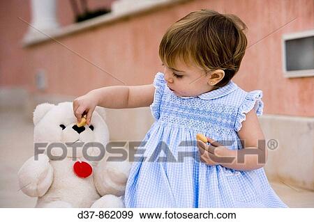 Stock Photo - Little girl playing with a teddy bear. Fotosearch