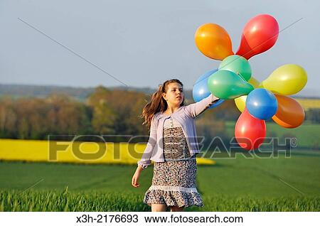 Stock Image - little girl playing with balloons in the fields, Eure-et-Loir department, Centre region, France, Europe.. Fotosearch