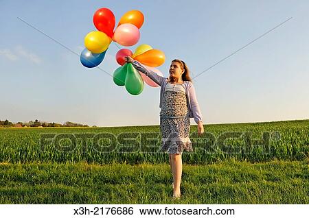 Stock Photograph - little girl playing with balloons in the fields, Eure-et-Loir department, Centre region, France, Europe.. Fotosearch