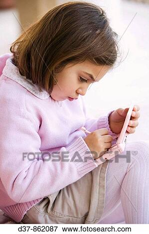 Little girl playing with her game boy View Large Photo Image Stock Photo - Little girl playing with her game boy. Fotosearch