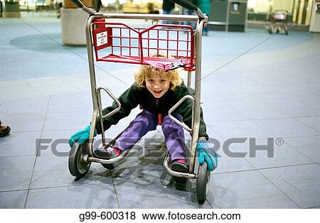 Little girl playing with luggage cart at airport View Large Photo Image Stock Photo - Little girl playing with luggage cart at airport. Fotosearch