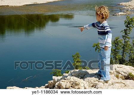 Little girl pointing at the surface of the Gardon river, Provence, France. View Large Photo Image Picture - Little girl pointing at the surface of the Gardon river, Provence, France.. Fotosearch