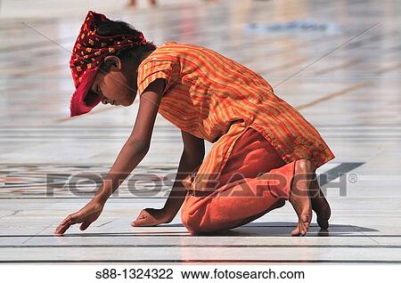 Stock Image - Little girl praying for the God in Golden Temple, Punjab Amritsar India. Fotosearch
