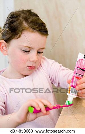 Little girl puting toothpaste on her teeth brush View Large Photo Image Stock Image - Little girl puting toothpaste on her teeth brush. Fotosearch