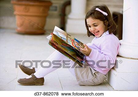 Little girl reading a book at home View Large Photo Image Stock Photo - Little girl reading a book at home. Fotosearch