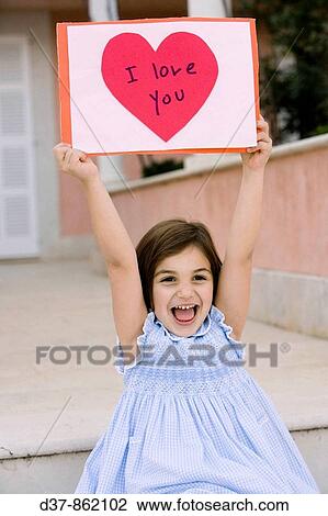Little girl showing a poster wiyh love View Large Photo Image Stock Image - Little girl showing a poster wiyh love. Fotosearch