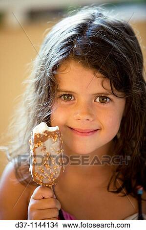 Picture - Little girl showing her ice cream satisfied. Fotosearch